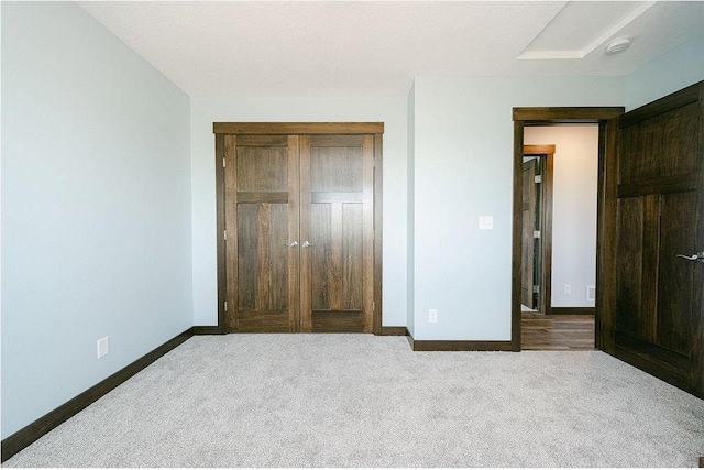 unfurnished bedroom with a closet, baseboards, and carpet