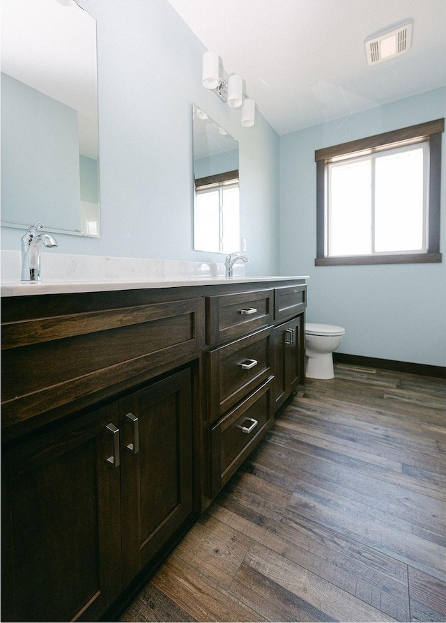 bathroom featuring hardwood / wood-style floors, a healthy amount of sunlight, toilet, and vanity