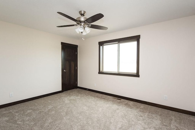 unfurnished room featuring a ceiling fan, carpet, and baseboards