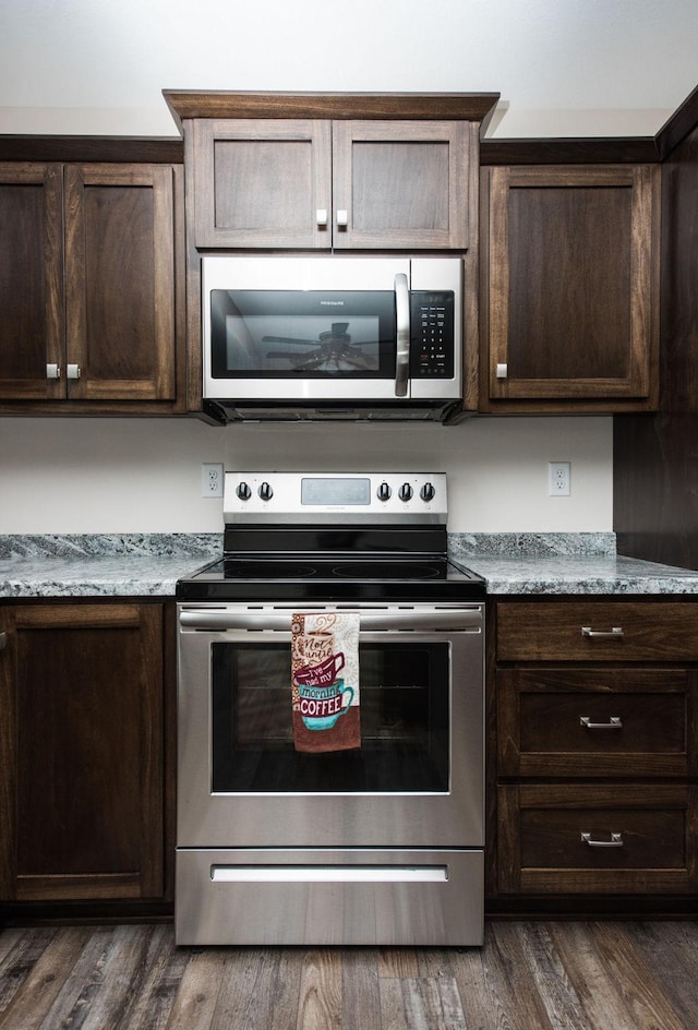 kitchen featuring dark brown cabinets, appliances with stainless steel finishes, and dark wood-style flooring