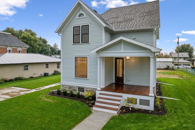 view of front of house featuring covered porch, roof with shingles, central air condition unit, and a front yard