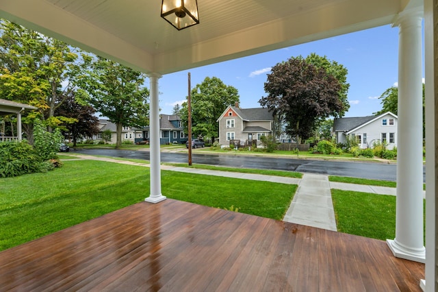 deck featuring a porch, a yard, and a residential view
