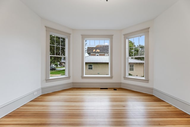 spare room featuring baseboards and wood-type flooring