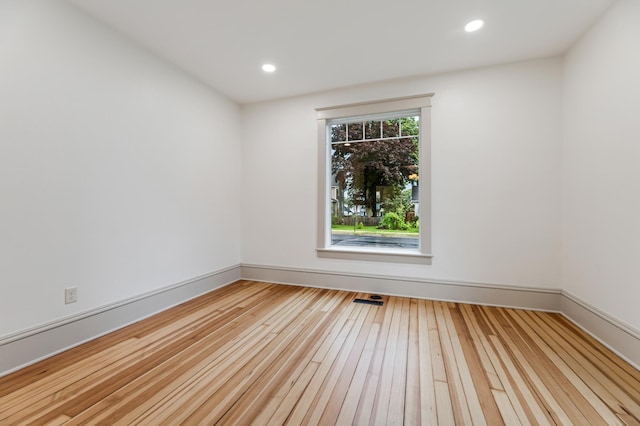 unfurnished room featuring baseboards, hardwood / wood-style floors, and recessed lighting