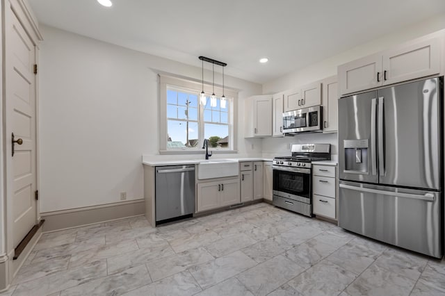 kitchen featuring a sink, stainless steel appliances, light countertops, marble finish floor, and recessed lighting