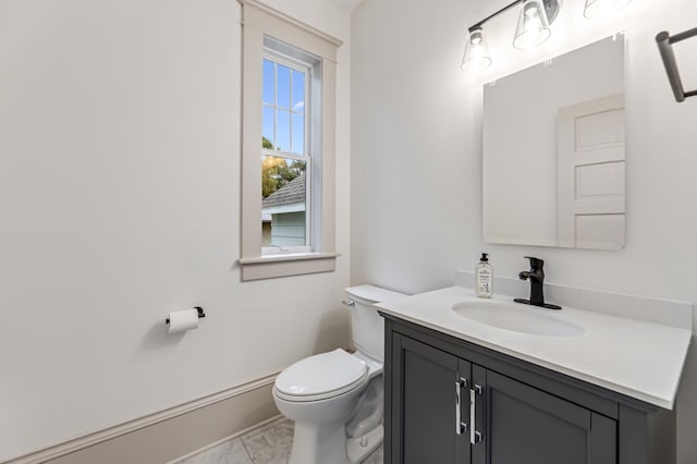 half bathroom with vanity, toilet, and marble finish floor