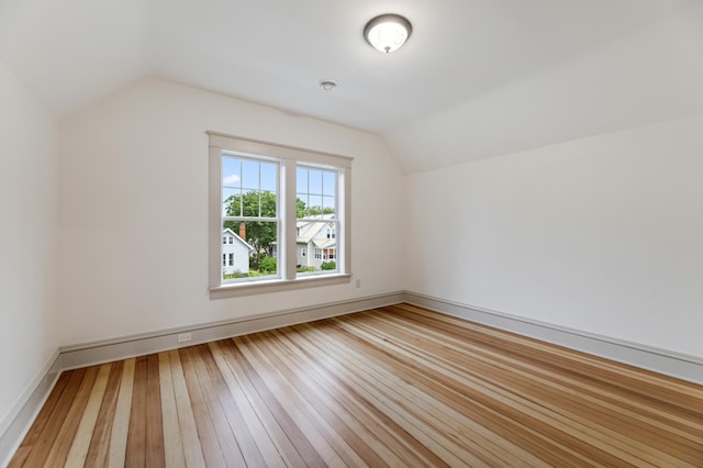 bonus room with baseboards, lofted ceiling, and hardwood / wood-style floors