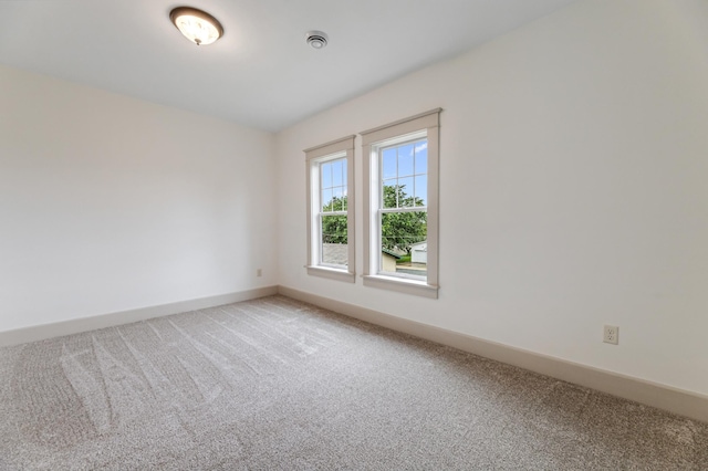 empty room featuring baseboards and light colored carpet
