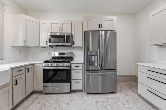 136 2nd Ave SE, Spring Grove, MN 55974 - kitchen featuring stainless steel appliances, light countertops, light marble finish floors, and baseboards
