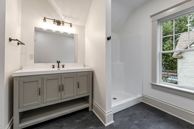 136 2nd Ave SE, Spring Grove, MN 55974 - full bathroom featuring vanity, a shower, baseboards, and vaulted ceiling