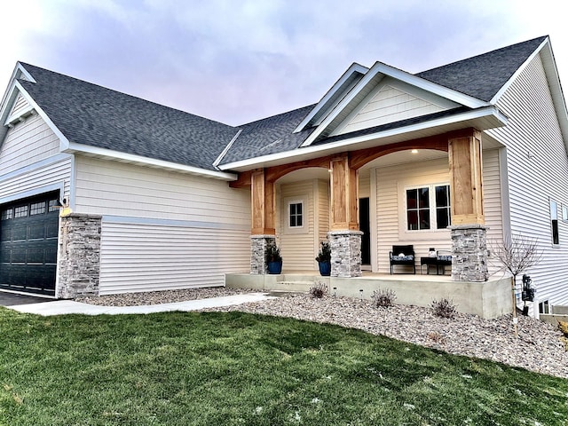 craftsman-style house featuring a garage, a front yard, and a porch