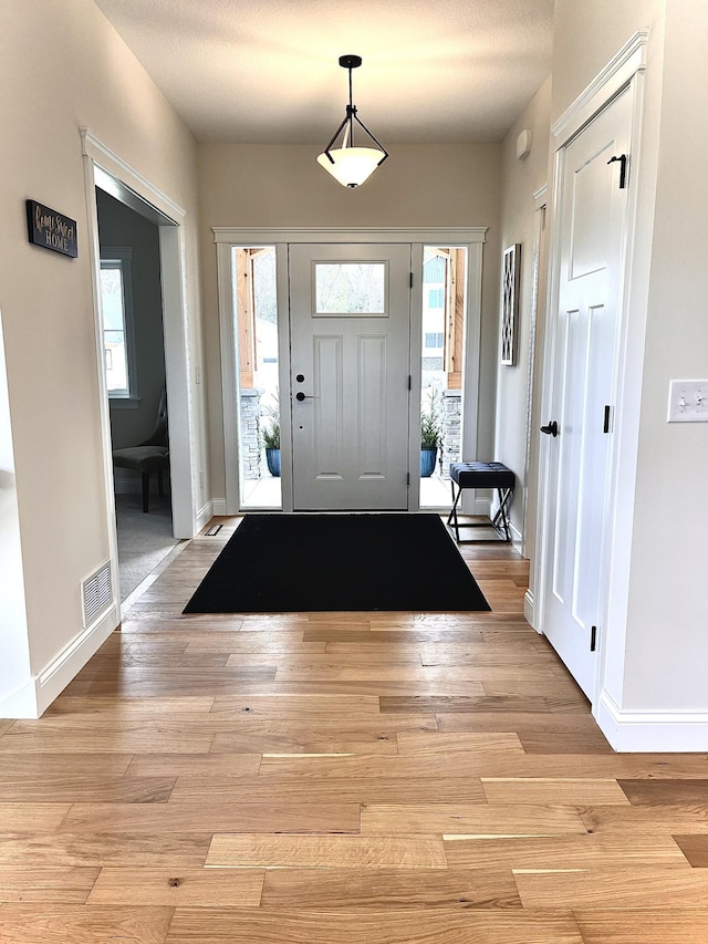 entryway with light hardwood / wood-style flooring and a healthy amount of sunlight