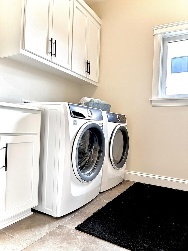 washroom featuring cabinets, light tile patterned floors, and separate washer and dryer