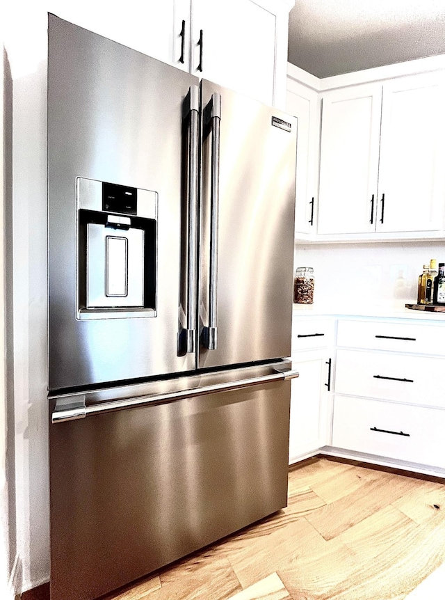 kitchen with light hardwood / wood-style flooring, white cabinets, and high end fridge