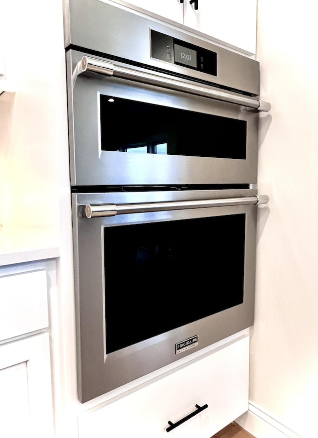 interior details with stainless steel double oven and white cabinetry