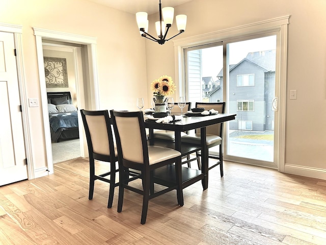 dining area featuring light hardwood / wood-style flooring and a chandelier