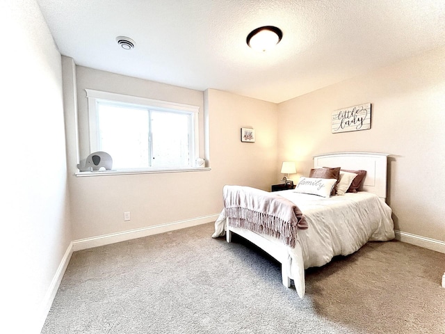 bedroom featuring a textured ceiling and carpet flooring