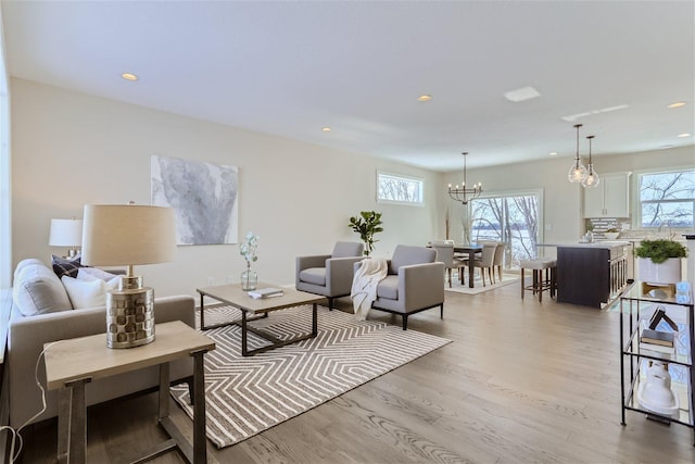 interior space featuring light wood-type flooring, plenty of natural light, and an inviting chandelier