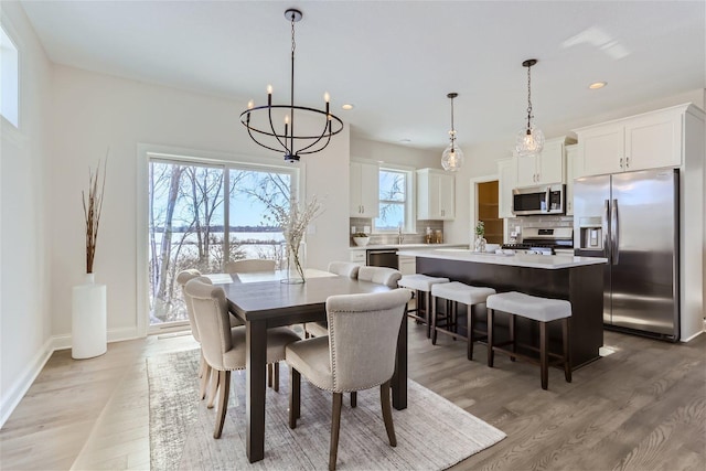 dining area featuring a notable chandelier and light hardwood / wood-style floors