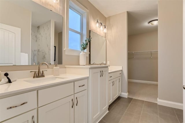 bathroom with a shower, tile patterned flooring, and vanity