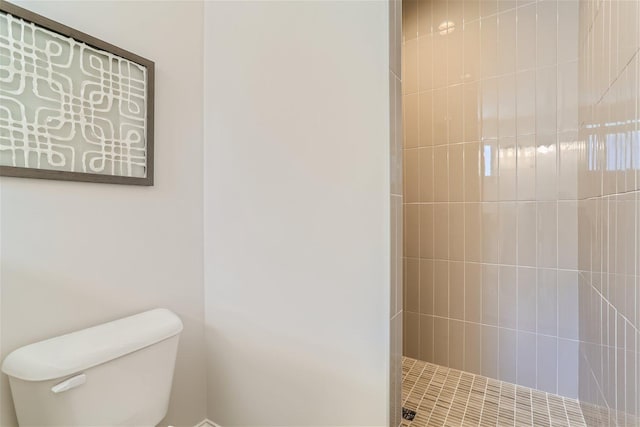 bathroom featuring toilet and a tile shower