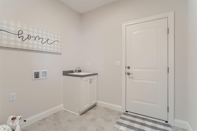 laundry area with hookup for a washing machine, cabinets, and sink