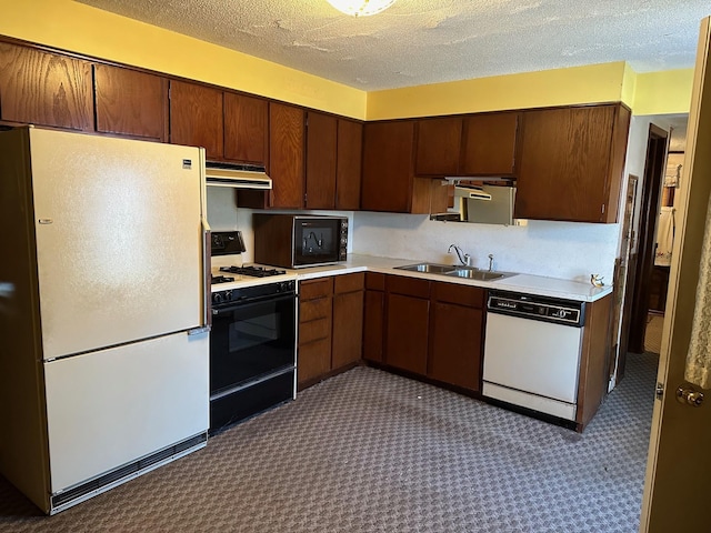 kitchen with dark colored carpet, white appliances, sink, and a textured ceiling