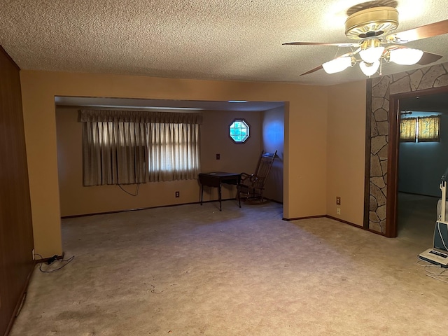 carpeted spare room featuring a textured ceiling and ceiling fan