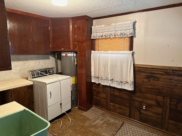 washroom featuring a textured ceiling, cabinets, gas water heater, and washer / clothes dryer