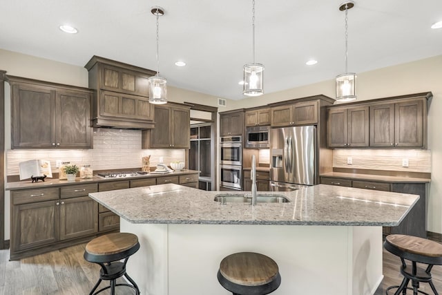 kitchen with stainless steel appliances, a kitchen breakfast bar, and decorative light fixtures