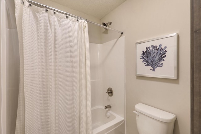 bathroom with toilet, shower / bath combo with shower curtain, and a textured ceiling