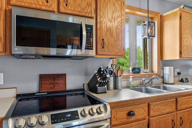 7702 County Road 5 NE, North Branch, MN 55056 - kitchen with appliances with stainless steel finishes, light countertops, pendant lighting, and brown cabinetry