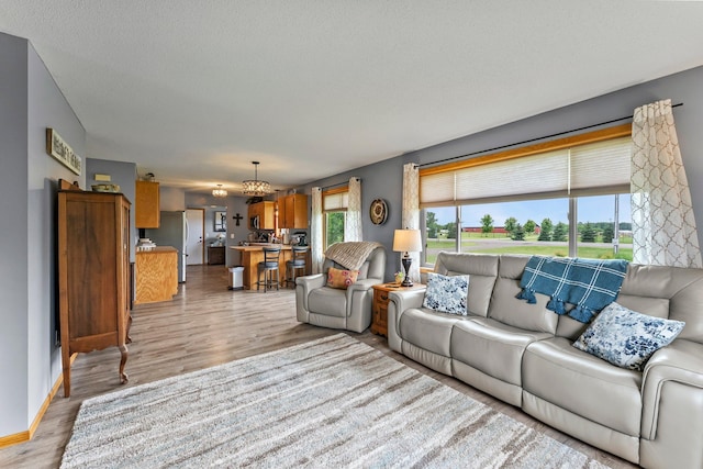 7702 County Road 5 NE, North Branch, MN 55056 - living area with light wood finished floors, a chandelier, and healthy amount of natural light