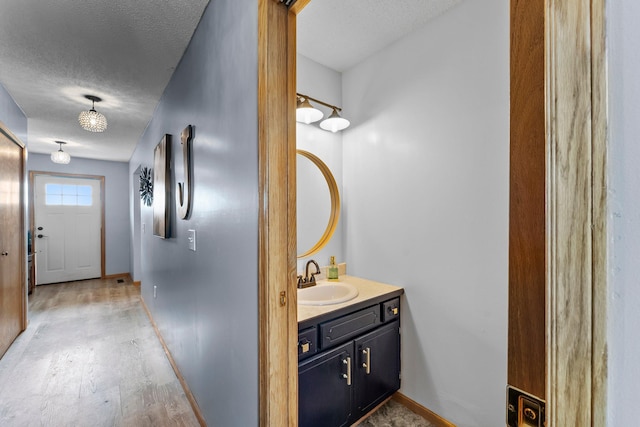 7702 County Road 5 NE, North Branch, MN 55056 - bathroom featuring vanity, wood finished floors, and a textured ceiling