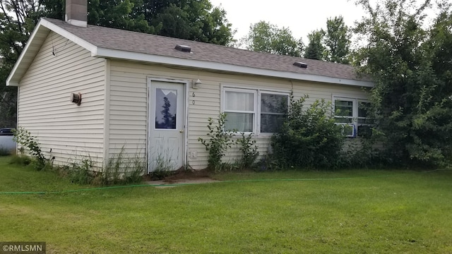 view of side of home with a yard