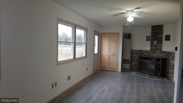 unfurnished living room with hardwood / wood-style floors, a healthy amount of sunlight, a brick fireplace, and ceiling fan