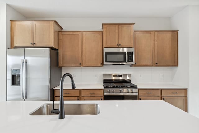 kitchen featuring tasteful backsplash, sink, and appliances with stainless steel finishes