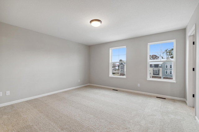 spare room featuring light carpet