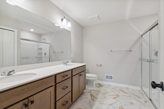 bathroom featuring a shower with door, vanity, and toilet