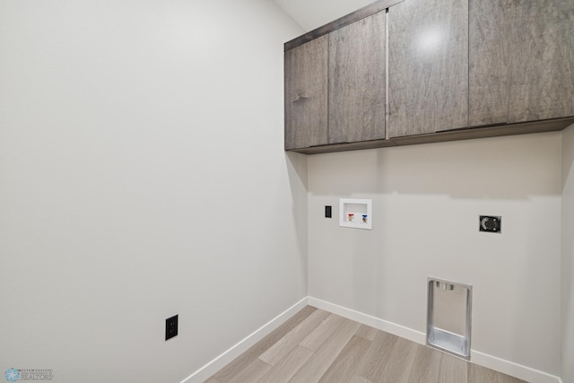 clothes washing area with electric dryer hookup, light wood-type flooring, cabinet space, baseboards, and hookup for a washing machine