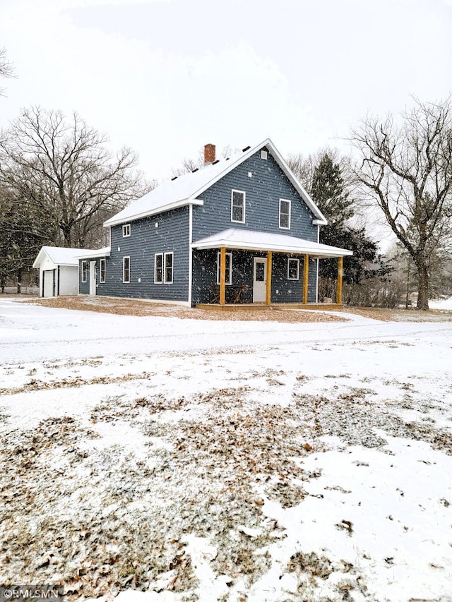 snow covered house featuring covered porch