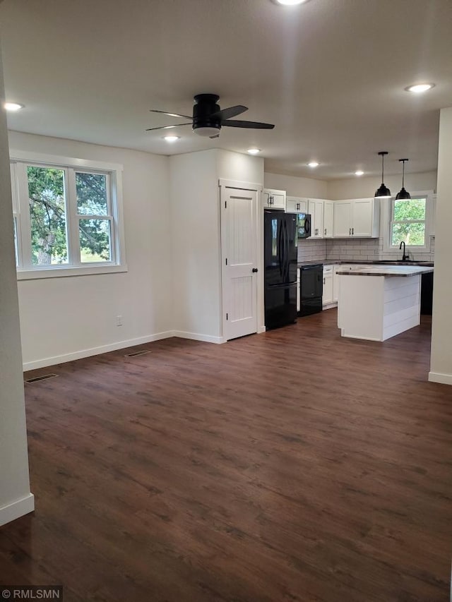 kitchen with white cabinetry, dark hardwood / wood-style floors, pendant lighting, decorative backsplash, and black appliances