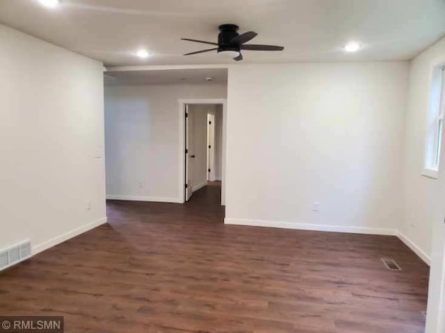 spare room with dark hardwood / wood-style flooring and ceiling fan