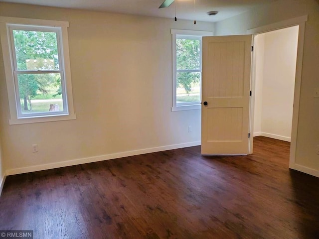 empty room featuring ceiling fan and dark hardwood / wood-style flooring