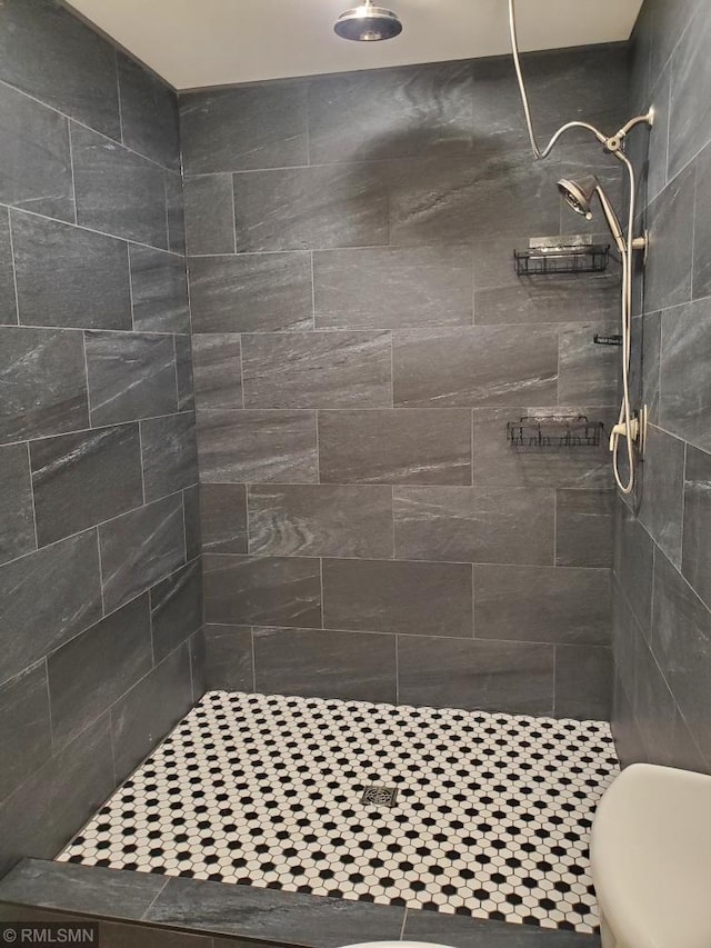 bathroom with tiled shower and toilet