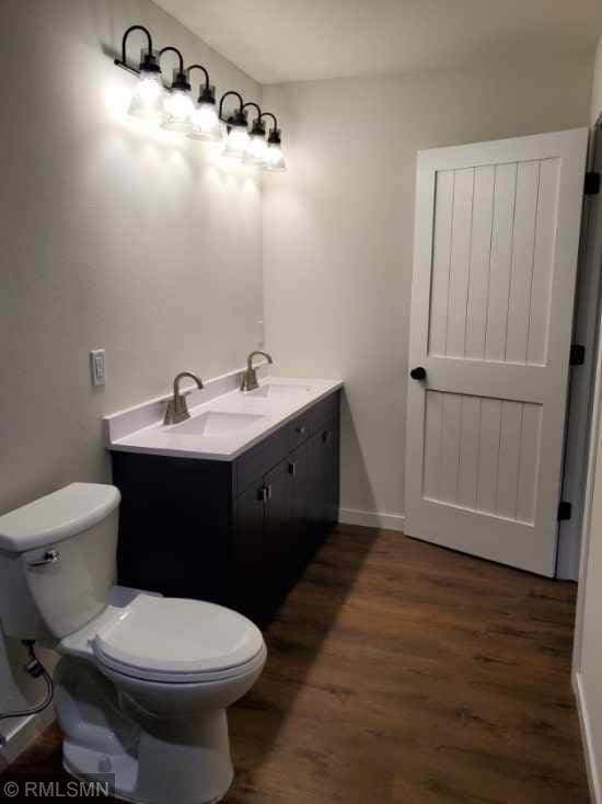 bathroom with hardwood / wood-style floors, vanity, and toilet