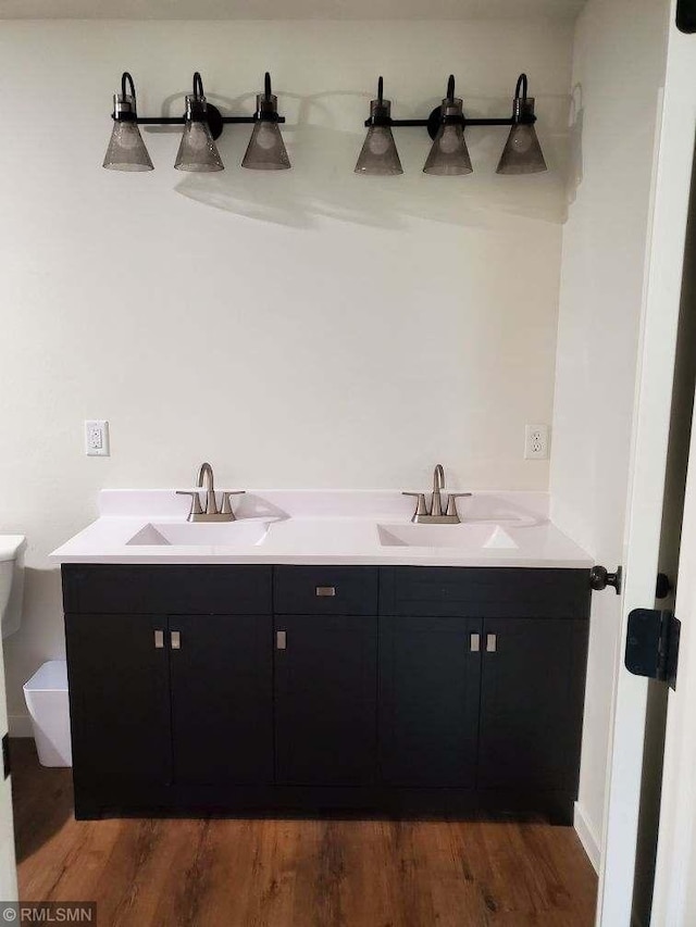 bathroom featuring wood-type flooring, vanity, and toilet