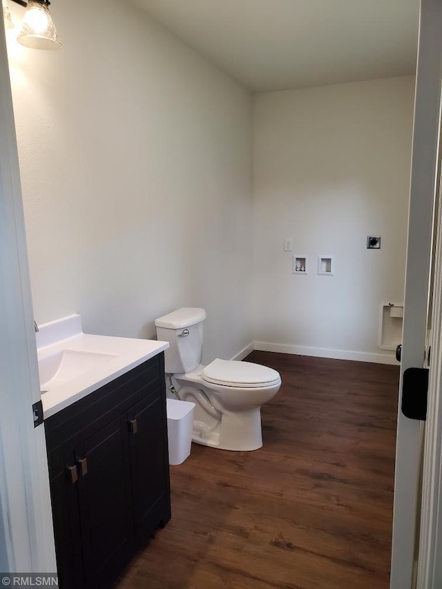 bathroom with toilet, vanity, and hardwood / wood-style flooring