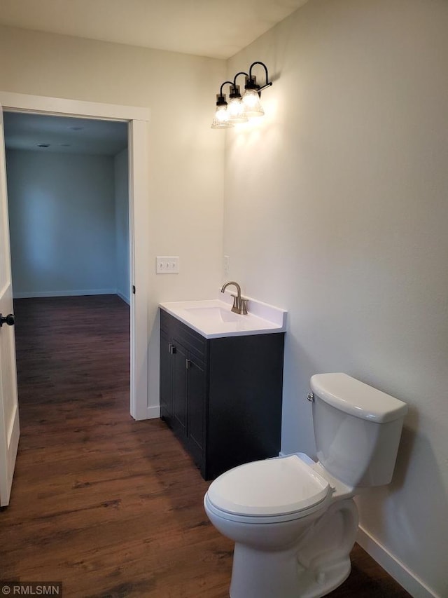 bathroom with hardwood / wood-style floors, vanity, and toilet