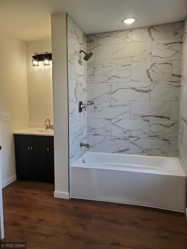 bathroom with vanity, wood-type flooring, and tiled shower / bath combo